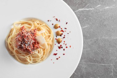 Plaka ile lezzetli makarna bolognese gri arka planda, üstten görünüm