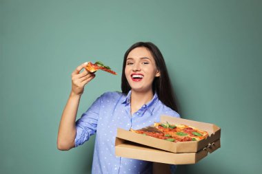 Lezzetli pizza renk arka plan üzerinde çekici genç kadın