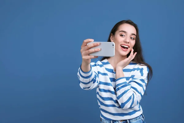 Attraktive Junge Frau Macht Selfie Mit Handy Auf Farbigem Hintergrund — Stockfoto