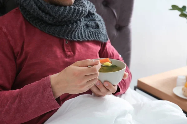 Syg Ung Mand Spiser Bouillon Til Helbrede Kulde Sengen Derhjemme - Stock-foto