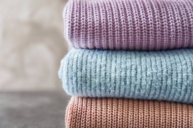 Gri arka plan üzerinde sıcak örme giysiler yığını