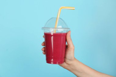 Güler yüzlü lezzetli renk arka plan üzerinde ile plastik bardak tutan kadın