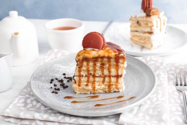 Lezzetli ev yapımı kek karamel sos ve masada macaron parçası