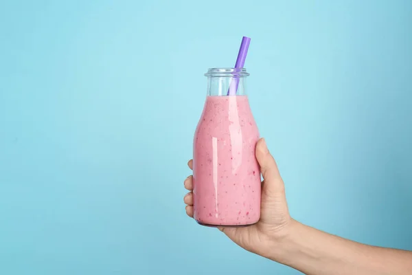 Frau Hält Flasche Mit Leckerem Smoothie Auf Farbigem Hintergrund — Stockfoto