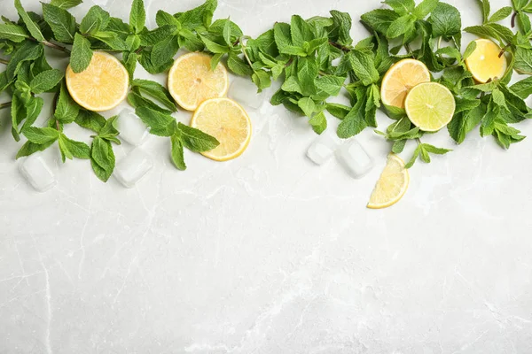 Flat lay composition with mint, citrus fruit and ice cubes on light background