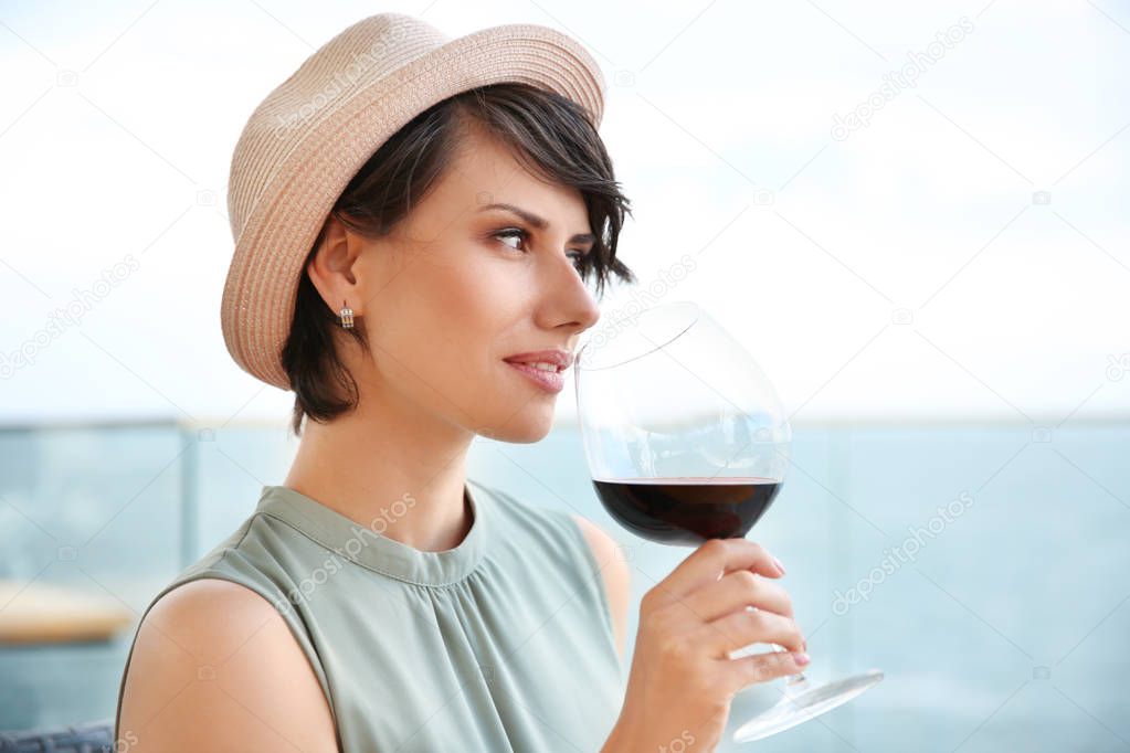 Young woman with glass of red wine outdoors