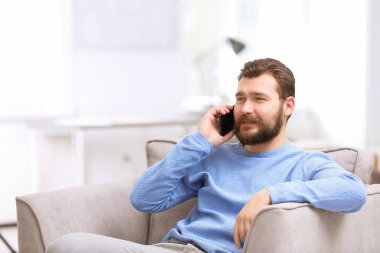 Hareket eden telefon içinde koltuk ile kendine güvenen olgun adam portresi