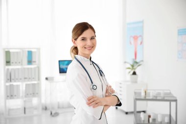 Smiling female doctor wearing uniform in modern hospital. Gynecology consultation clipart
