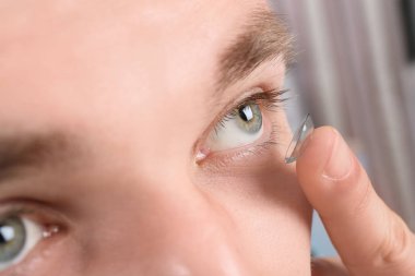 Genç koyarak Kontakt lens gözüne, tatlı adam.