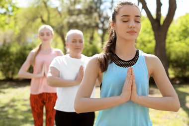Kadınlar pratik yoga Park güneşli günde gurup