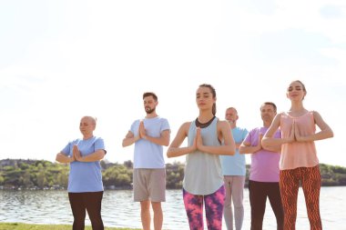 Pratik yoga Nehri yakınında güneşli günde gurup