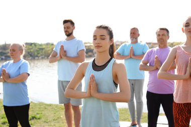 Pratik yoga Nehri yakınında güneşli günde gurup