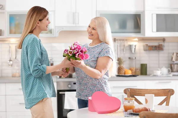 Hija Felicitando Mujer Madura Feliz Día Madre Casa — Foto de Stock