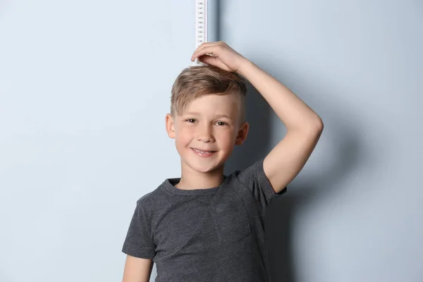 Liten Pojke Mätning Hans Höjd Ljus Bakgrund — Stockfoto