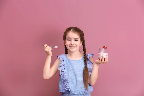 可爱的女孩吃可口的酸奶在颜色背景 — 图库照片