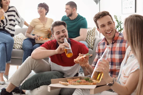 年轻人有愉快的党与美味的比萨室内 — 图库照片
