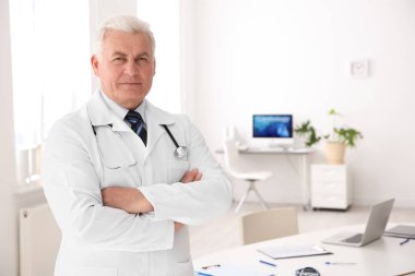 Klinikte işyerinde paltolu erkek doktor portresi. Kardiyoloji Merkezi