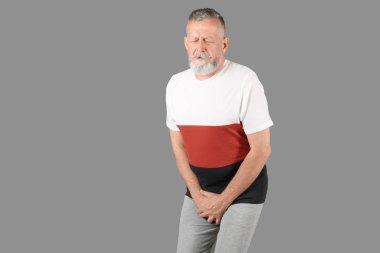 Üroloji sorunları gri arka plan üzerinde acı acı olan olgun adam