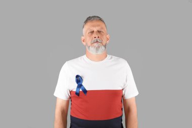 Mature man with blue ribbon on grey background. Urological cancer awareness clipart