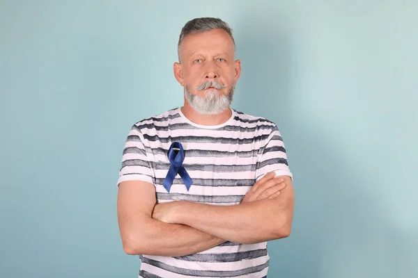成熟的人与蓝色丝带在颜色背景 泌尿外科癌症意识 — 图库照片