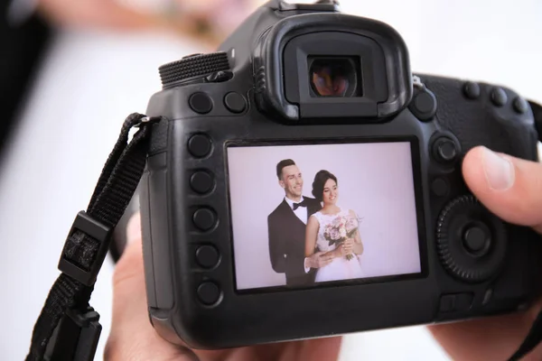 Professionele Fotograaf Vasthouden Van Camera Met Mooie Bruidspaar Tentoongesteld Close — Stockfoto