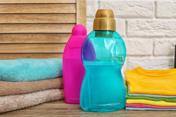 Saubere Kleidung Handtücher Und Flaschen Mit Waschmitteln Auf Dem Tisch — Stockfoto