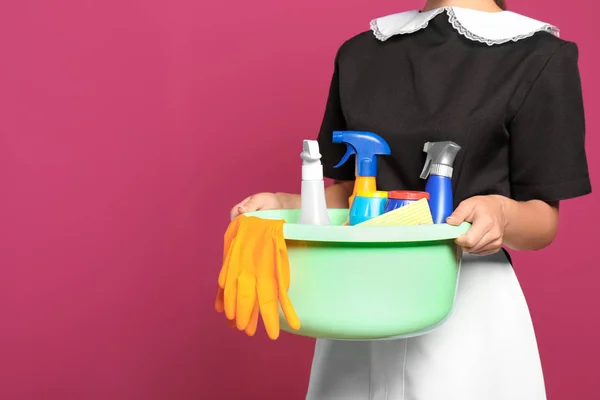 Młoda Pokojówka Trzymając Plastikowe Basenu Detergentów Kolor Tła — Zdjęcie stockowe