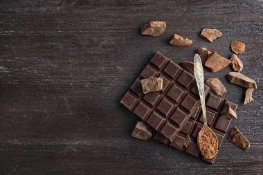 Kaşık kakao tozu ve lezzetli çikolata karanlık tablo, üstten görünüm