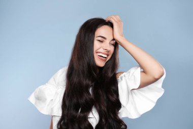 Gri arka plan üzerinde muhteşem kıvırcık saçlı güzel model portresi