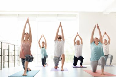 Bir grup insan pratik yoga kapalı spor giyim