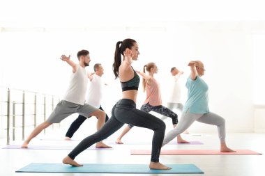 Bir grup insan pratik yoga kapalı spor giyim