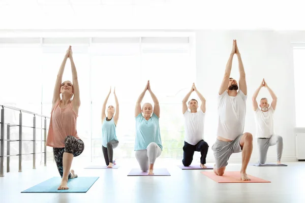 一群人在运动服练习室内瑜伽 — 图库照片