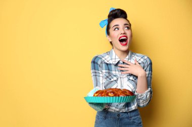 Renk arka plan üzerinde ev yapımı hamur işleri ile komik genç ev hanımı