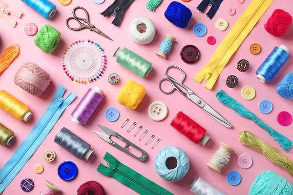 Composition with threads and sewing accessories on color background, flat lay