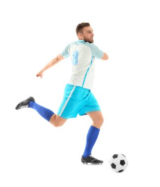 Genç adam beyaz arka planda futbol oynuyor.