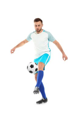 Genç adam beyaz arka planda futbol oynuyor.