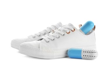 Beyaz arka plan üzerinde kapsül Ayakkabı spreyleri ile spor ayakkabı