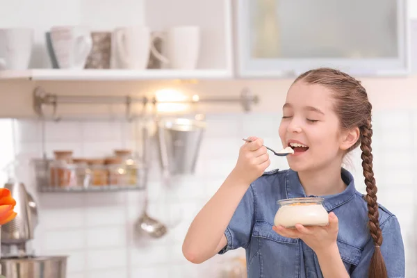 かわいい女の子のキッチンでおいしいヨーグルトを食べて — ストック写真