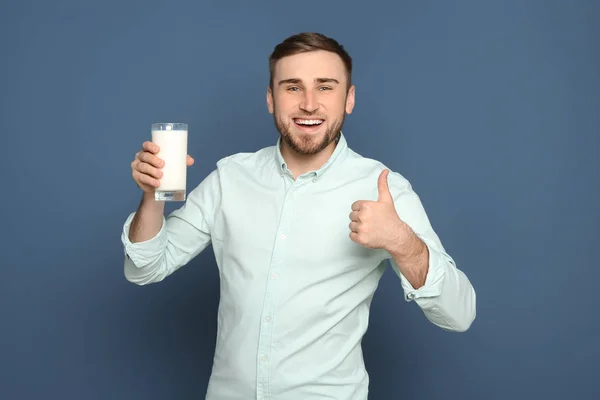 おいしい牛乳色の背景上のガラスと若い男 — ストック写真