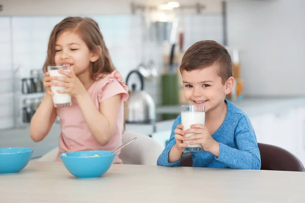 かわいい子供たちが台所で牛乳を飲んで — ストック写真