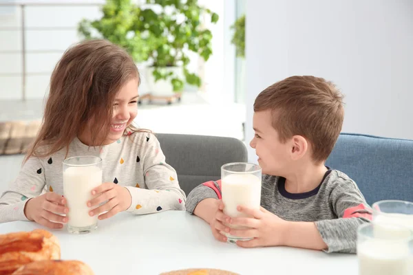 かわいい小さな子供たちのテーブルで牛乳で朝食を済ませ — ストック写真