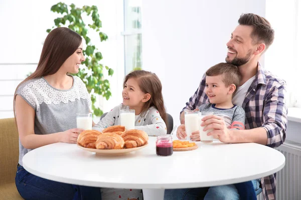 Happy family having breakfast with milk at table