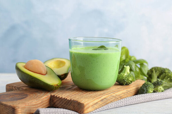 Glass with healthy detox smoothie and ingredients on table