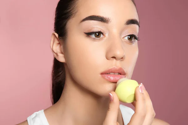 Młoda Kobieta Stosując Balsam Jej Usta Przed Kolor Tła — Zdjęcie stockowe