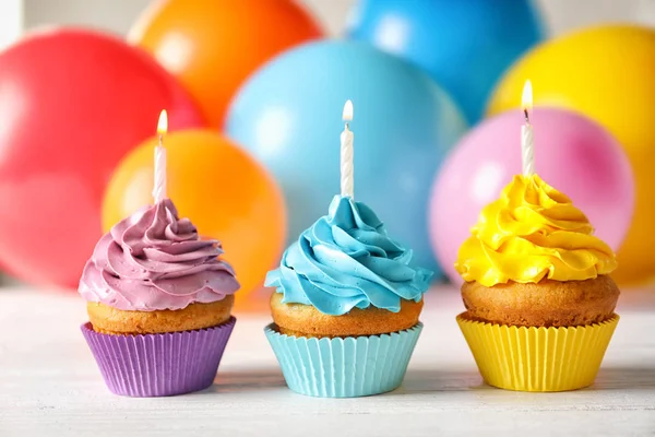 Deliciosos Cupcakes Cumpleaños Con Velas Globos Borrosos Fondo —  Fotos de Stock