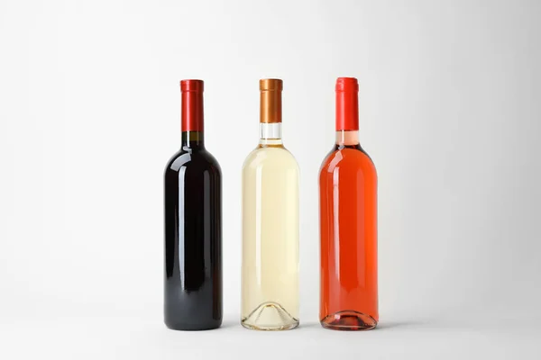 Bottles of expensive wines on light background