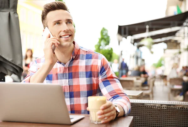 Jovem Falando Telefone Enquanto Trabalhava Com Laptop Mesa Café — Fotografia de Stock