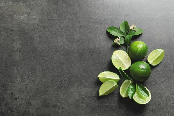 Gri arka plan, üstten görünüm üzerinde olgunlaşmış taze limes ile kompozisyon