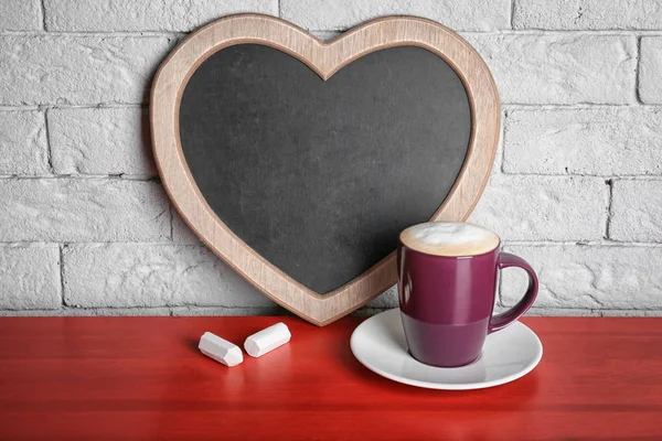 Kopp Kaffe Bordet Nära Hjärtformade Chalkboard — Stockfoto