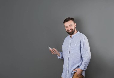Renk arka plan üstünde hareket eden telefon ile yakışıklı sakallı adam portresi